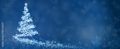 Christmas time. Christmas tree with stars and snowflakes in blue winter landscape.