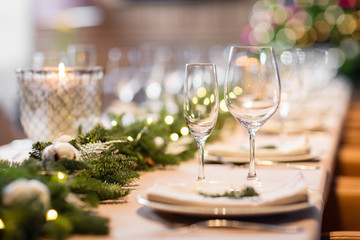 Christmas dinner feast. A decorated dining table with champagne glasses and christmas tree in background