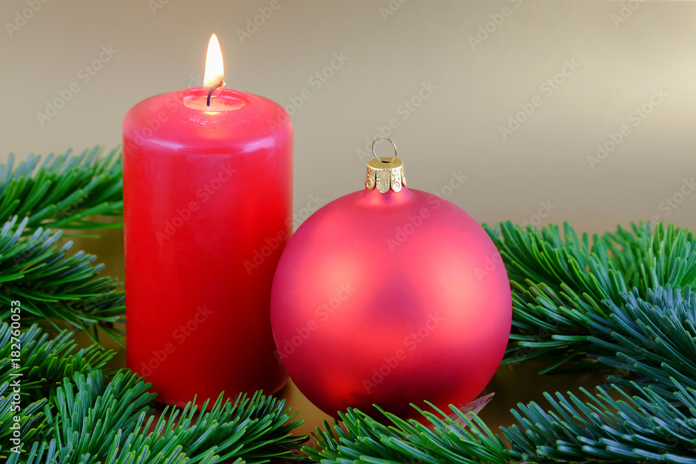Christmas composition with red candle, Christmas ball and fir branches.