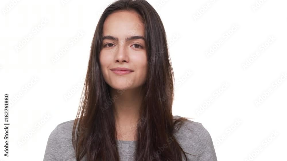 portrait of beautiful female model looking at camera touching her long dark hair smiling isolated over white background closeup. Concept of emotions portrait of beautiful female model looking at camera touching her long dark hair smiling isolated over white background closeup. Concept of emotions