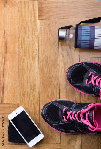 Sport shoes with bottle and phone on floor