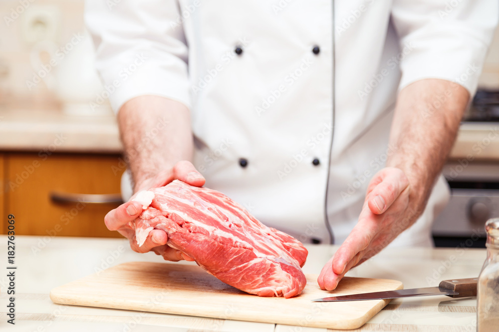 Professional cook men show a piece of meat. Close up