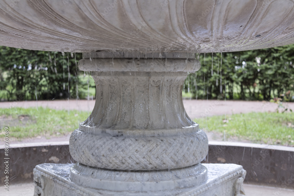 This fountain belongs to a greco roman patio in the city park. the eorsion of wáter certainly shows how old this is, but it is still in great condition. the reflection and the droplets make it a beaut