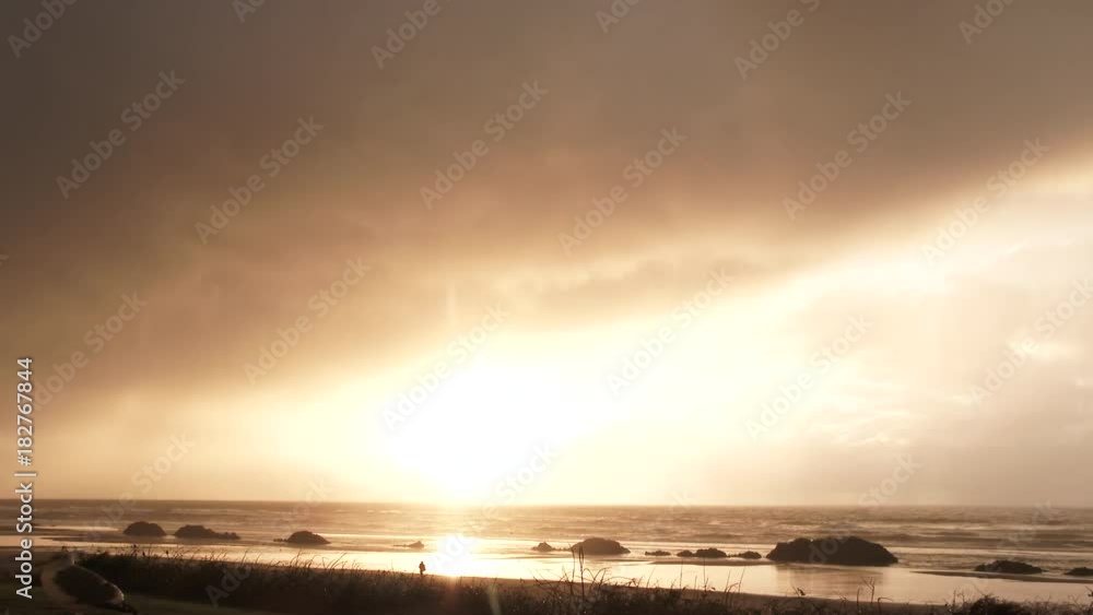 Look closely and you will see the ocean rain coming down at sunset on beautiful and calm Oregon beach. Look closely and you will see the ocean rain coming down at sunset on beautiful and calm Oregon beach.