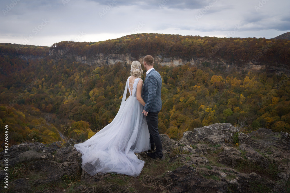 Beautiful couple in the mountains of the wedding in autumn groom and bride Beautiful couple in the mountains of the wedding in autumn groom and bride