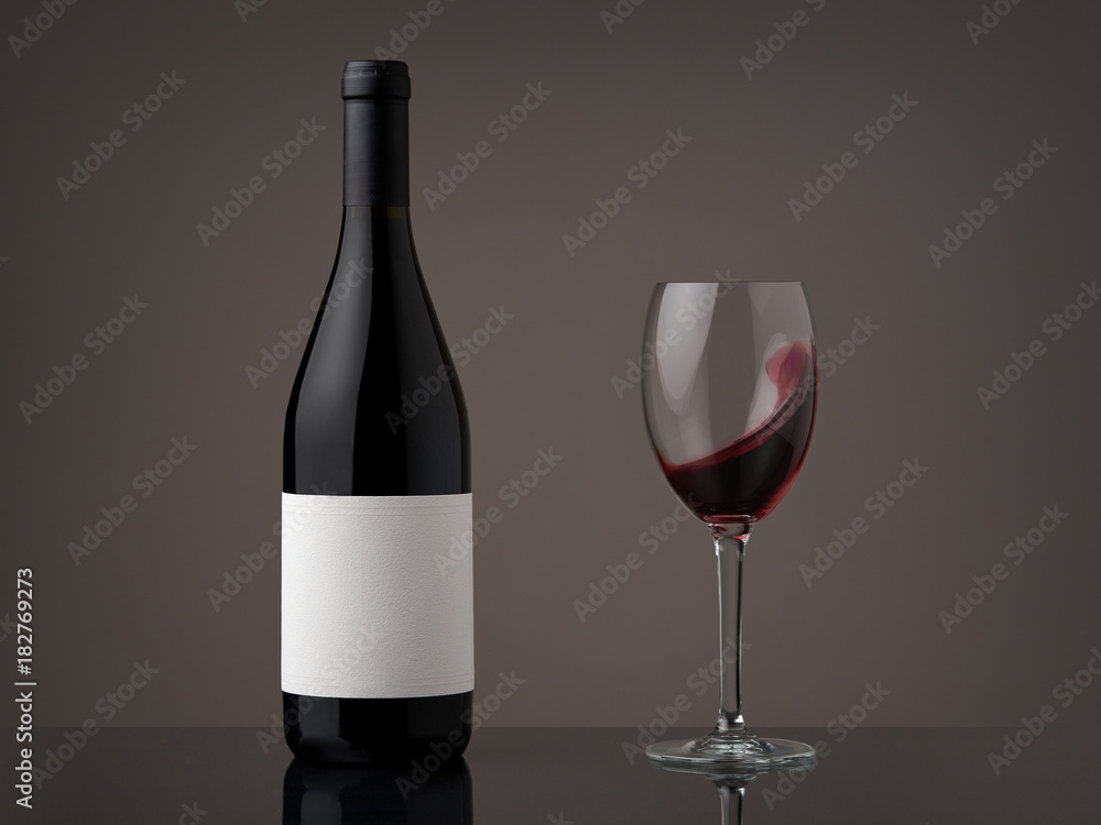 Wine bottle with wineglass. Red wine wave in a glass Wine bottle with wineglass. Red wine wave in a glass