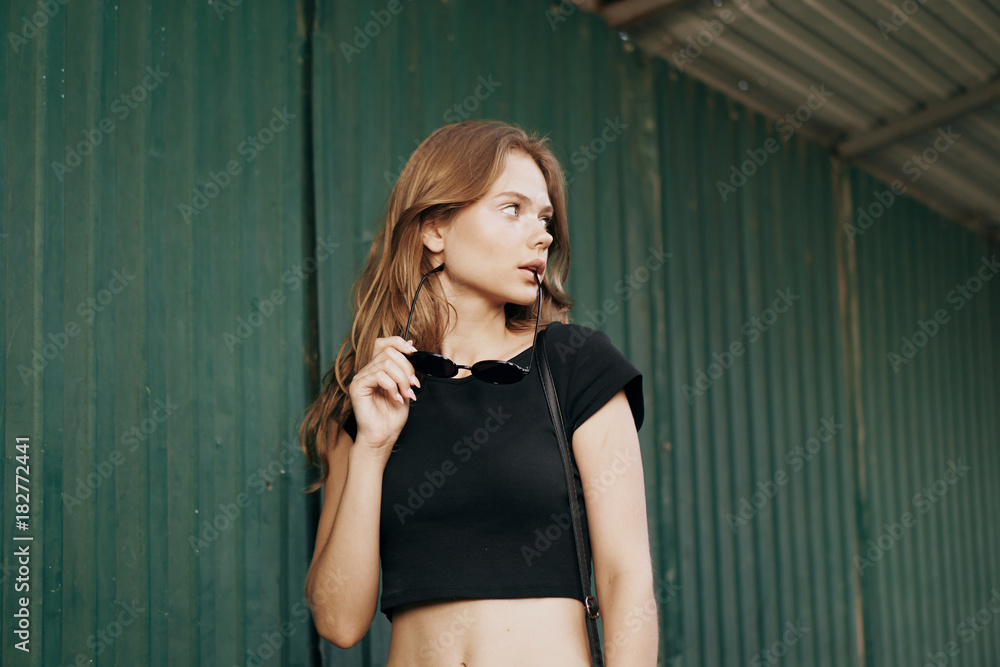 Fototapeta premium girl posing against the green fence