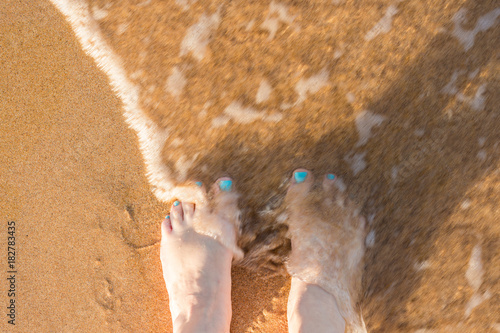 toes in the sand, with water