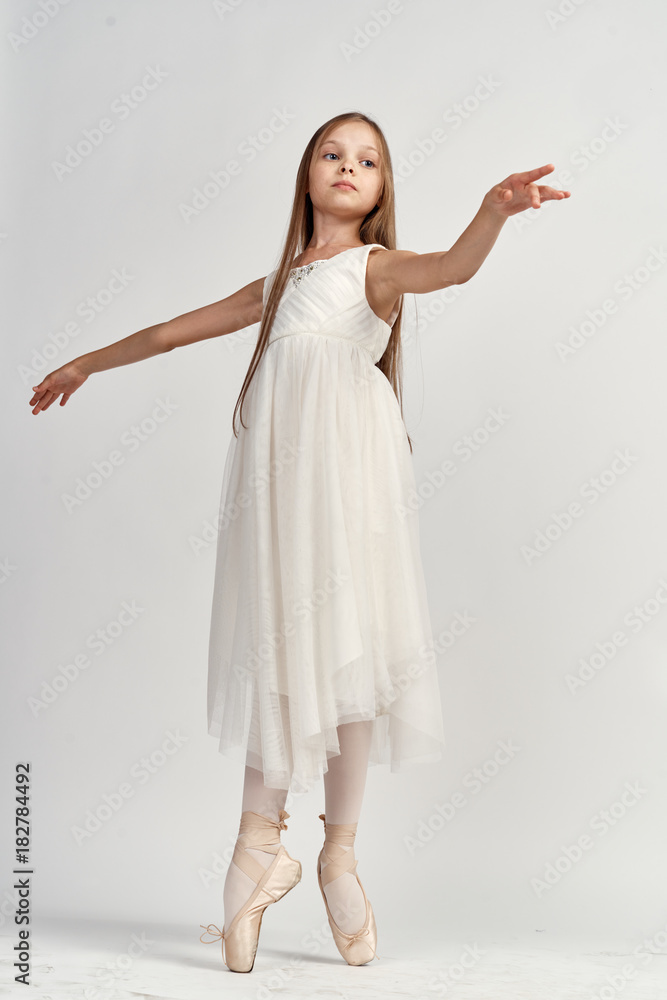 young ballerina in a light dress and pointe poses young ballerina in a light dress and pointe poses