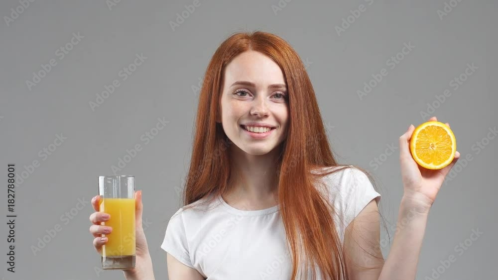 Girl holding glass of orange juice and laughing at camera. Girl holding glass of orange juice and laughing at camera.