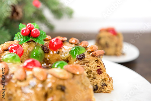 Colorful delicious homemade Christmas fruit cake on white platter