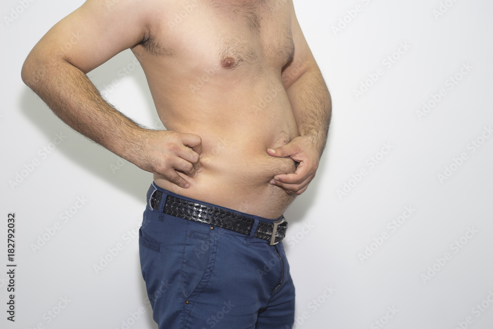 Naklejka premium Man hands holding belly fat. Young man show belly fat.
