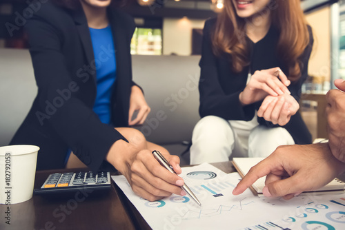 Financial adviser working with clients analyzing data at the table
