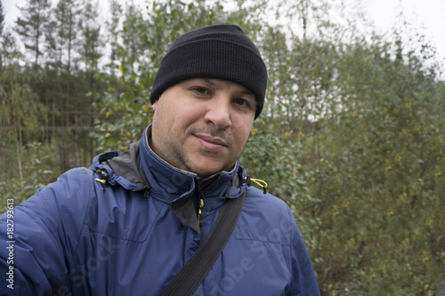 Man sitting and makes selfie in forest. holding hands.