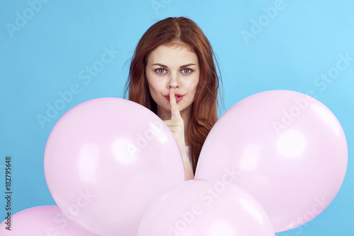 a woman in the middle of pink balls put a finger to her mouth © SHOTPRIME STUDIO