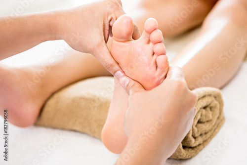 Foto Therapist giving relaxing reflexology Thai foot massage to a woman in spa
