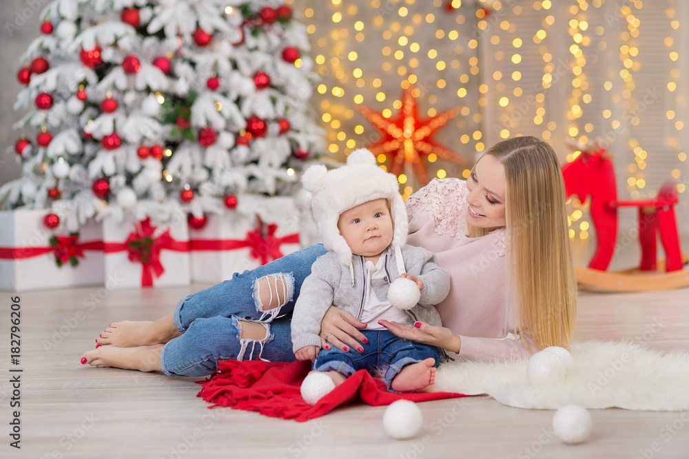 happy family mother and baby little son playing home on Christmas holidays.Toddler with mom in the festively decorated room with Christmas tree. Portrait of mother and baby boy in casual clothes happy family mother and baby little son playing home on Christmas holidays.Toddler with mom in the festively decorated room with Christmas tree. Portrait of mother and baby boy in casual clothes