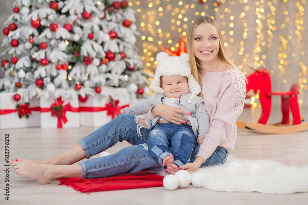 happy family mother and baby little son playing home on Christmas holidays.Toddler with mom in the festively decorated room with Christmas tree. Portrait of mother and baby boy in casual clothes happy family mother and baby little son playing home on Christmas holidays.Toddler with mom in the festively decorated room with Christmas tree. Portrait of mother and baby boy in casual clothes