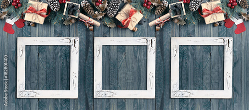 Christmas banner with photo frames, spruce, gift box, Santa Claus boots and scroll in vintage style on wooden boards background