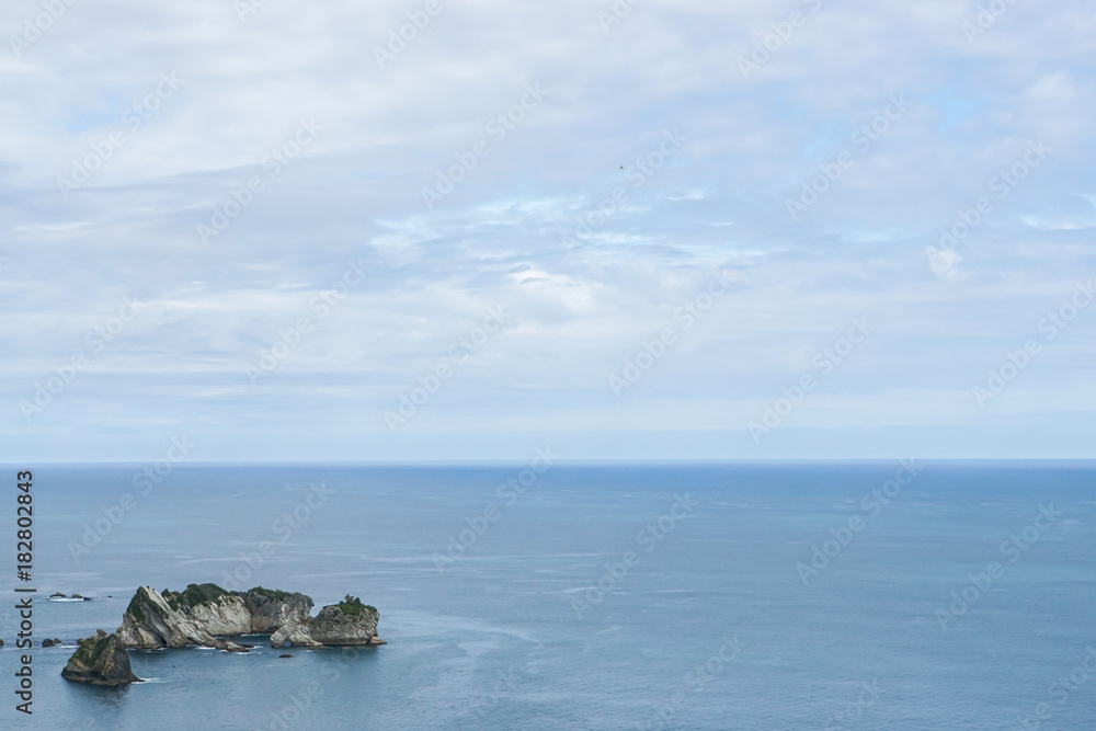 small island on blue Tasman sea in New Zealand