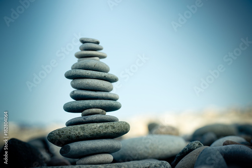 Foto Stone cairn on green blurry background, pebbles and stones