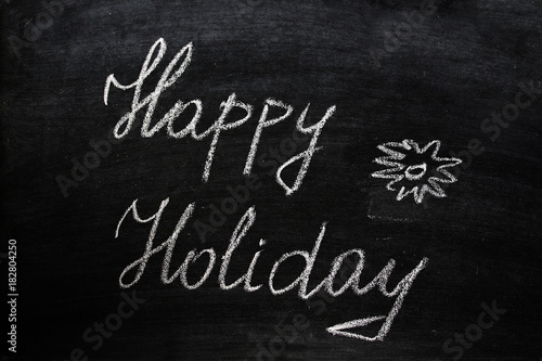 Happy Holiday Slogan Written On A Black Chalkboard