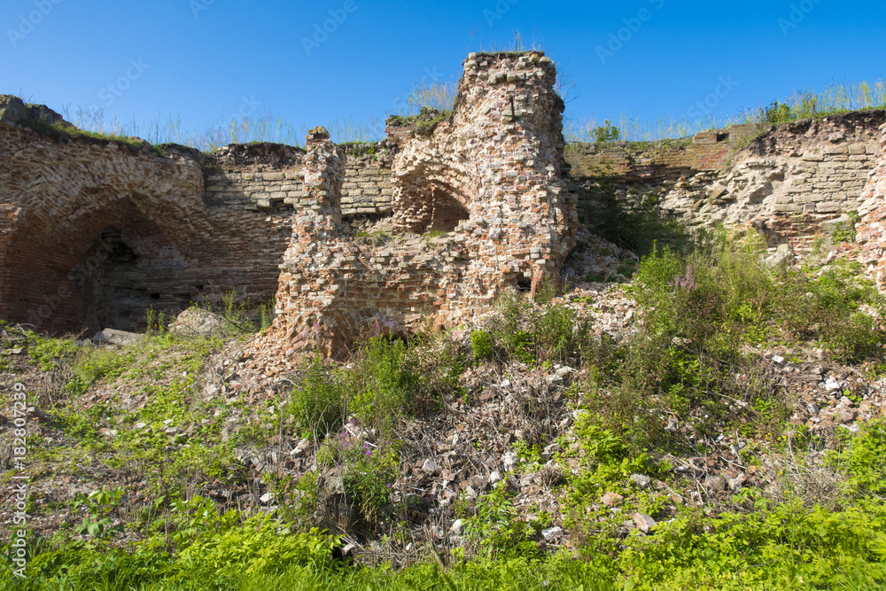 An old brick wall, the ruins of an ancient fortress in the summer.