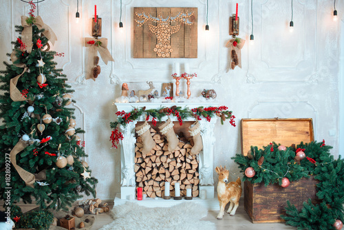 Beautiful holiday decorated room with Christmas tree, fireplace and with presents. Cozy winter scene. White interior.