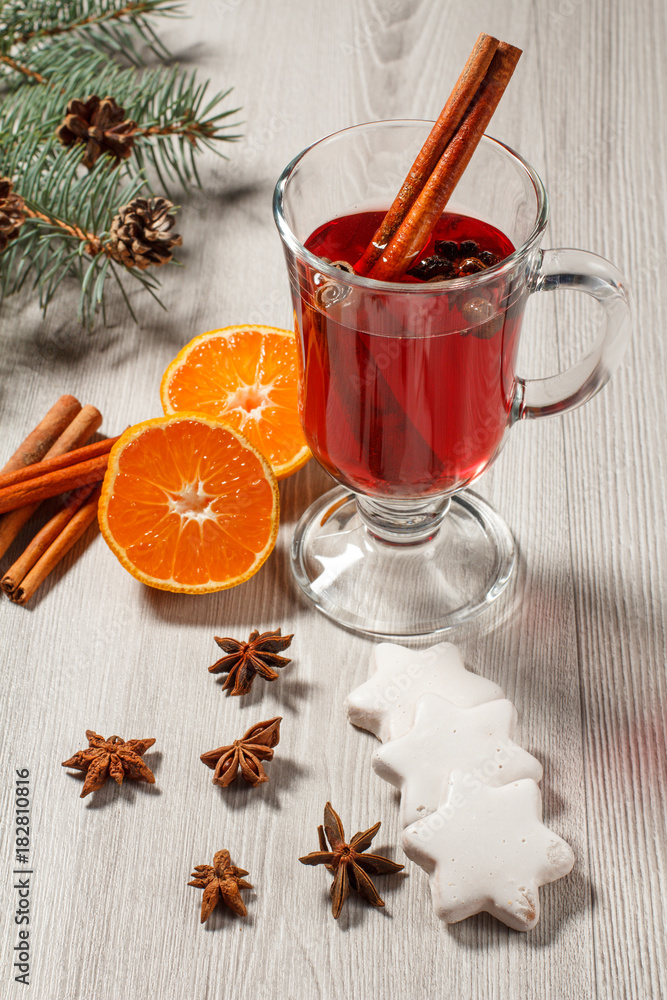 Glass of Christmas mulled wine with spices, orange and cookies on wooden background Glass of Christmas mulled wine with spices, orange and cookies on wooden background