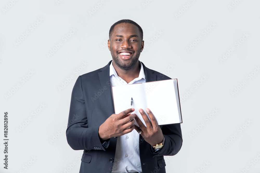 Attractive handsome happy smiling professional businessman holds an open book for entries. Afro American male. Attractive handsome happy smiling professional businessman holds an open book for entries. Afro American male.