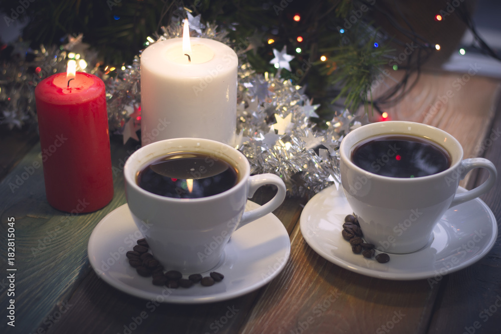 A romantic festive still life with burning candles and two cups of freshly brewed coffee. Dark Christmas background. Blurred bokeh A romantic festive still life with burning candles and two cups of freshly brewed coffee. Dark Christmas background. Blurred bokeh