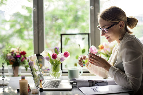 Woman smelling a flower in the office photo
