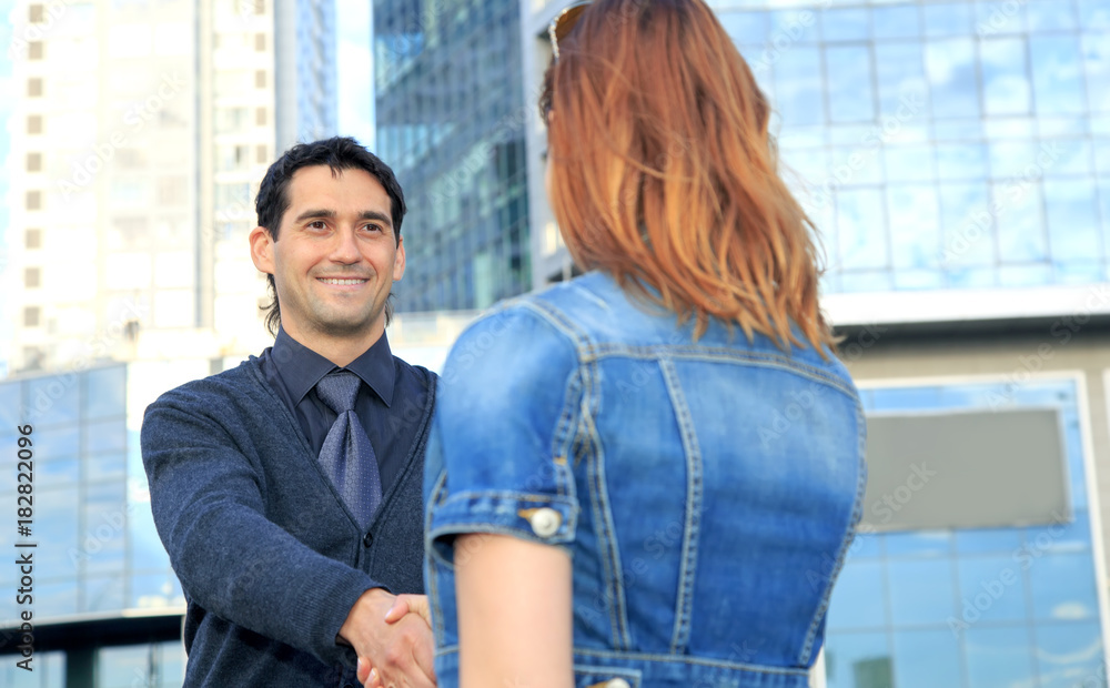 Business partners, handshake between a man and a woman, ready to seal a deal. Business partners, handshake between a man and a woman, ready to seal a deal.