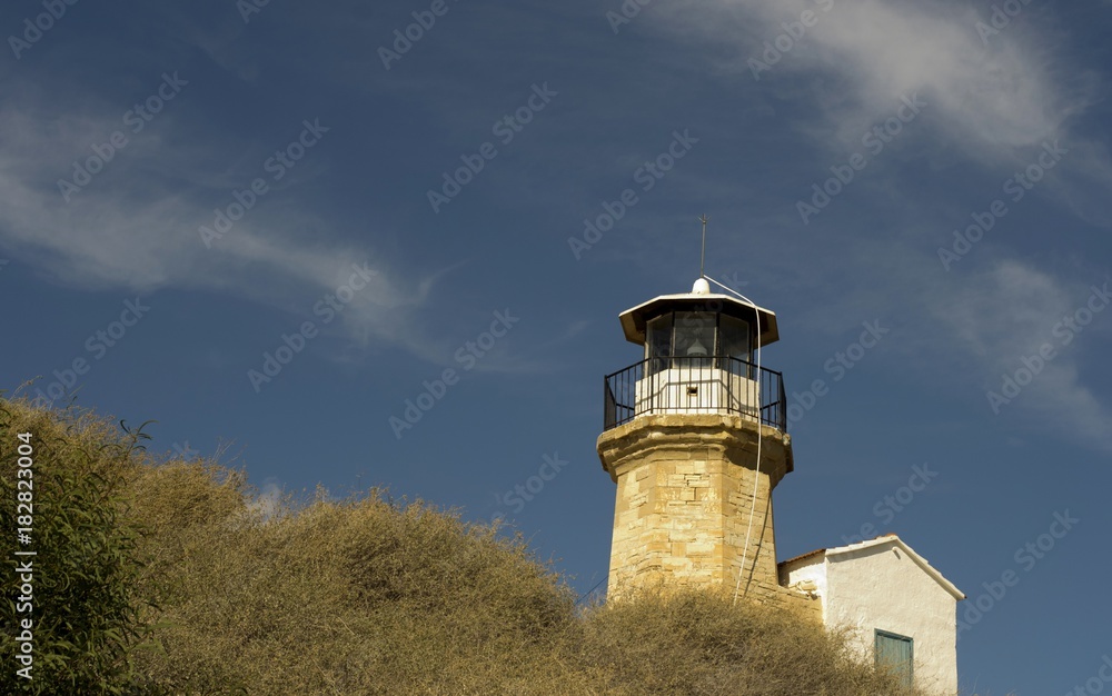 Outdoor architecture of an old lighthouse in Cyprus and cloudy blue sky