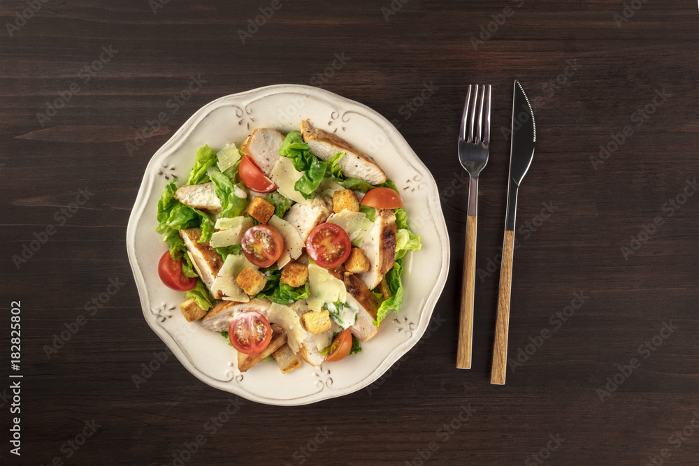 Chicken Caesar salad on dark rustic background with copyspace