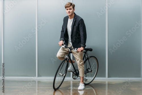 handsome young man on vintage bike indoors