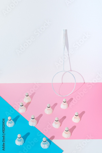 badminton racket and shuttlecocks on blue and pink papers at wall © LIGHTFIELD STUDIOS