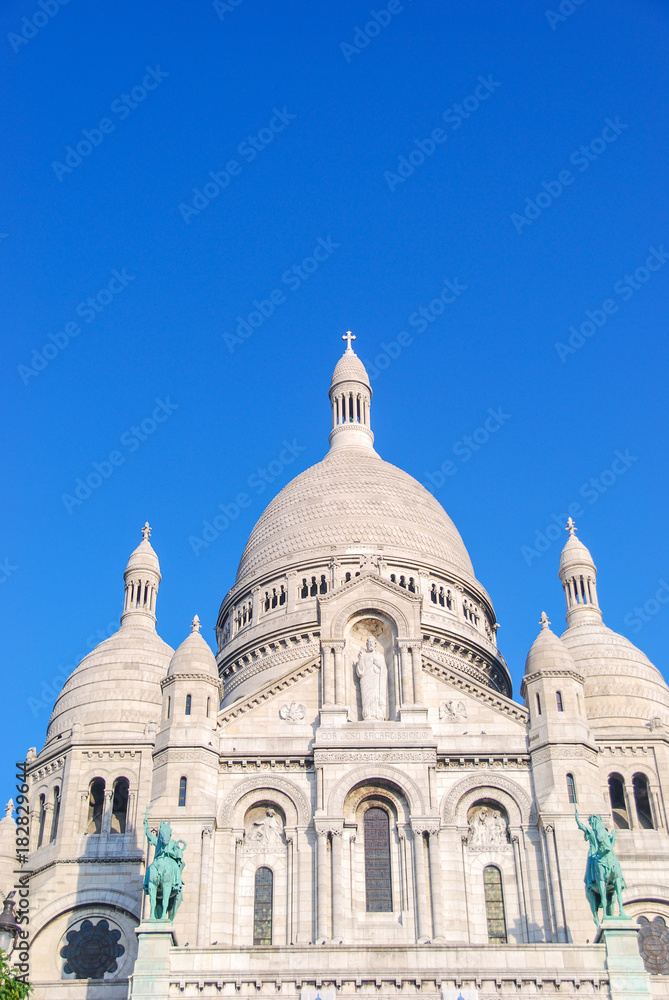 Sacré Coeur cathedral white facade front with deep blue sky above, Paris, France