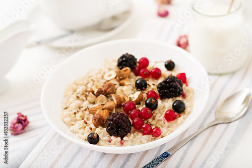 Tasty and healthy oatmeal porridge with berry, flax seeds and nuts. Healthy breakfast. Fitness food. Proper nutrition.