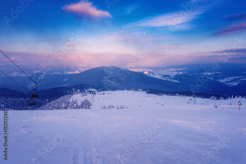 Winter mountain landscape at sunset, snowy hills of ski resort in Carpathians