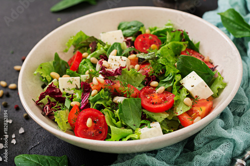 Dietary salad with tomatoes, feta, lettuce, spinach and pine nuts.