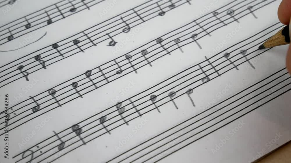 Composer Comes Down a Song and Records Musical Notes Of Melody On A Paper Leaf by Pensil Composer Comes Down a Song and Records Musical Notes Of Melody On A Paper Leaf by Pensil