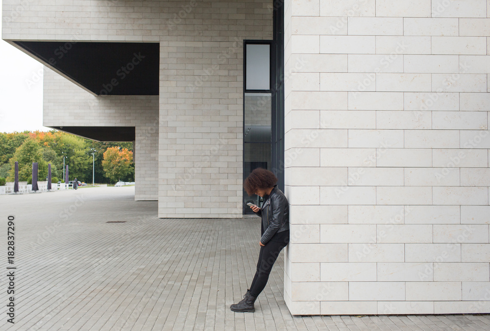 Young woman with smartphone near building Young woman with smartphone near building