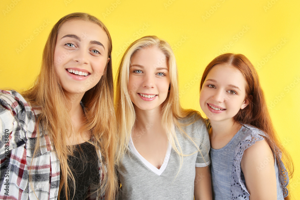 Cute teenagers taking selfie on color background Cute teenagers taking selfie on color background