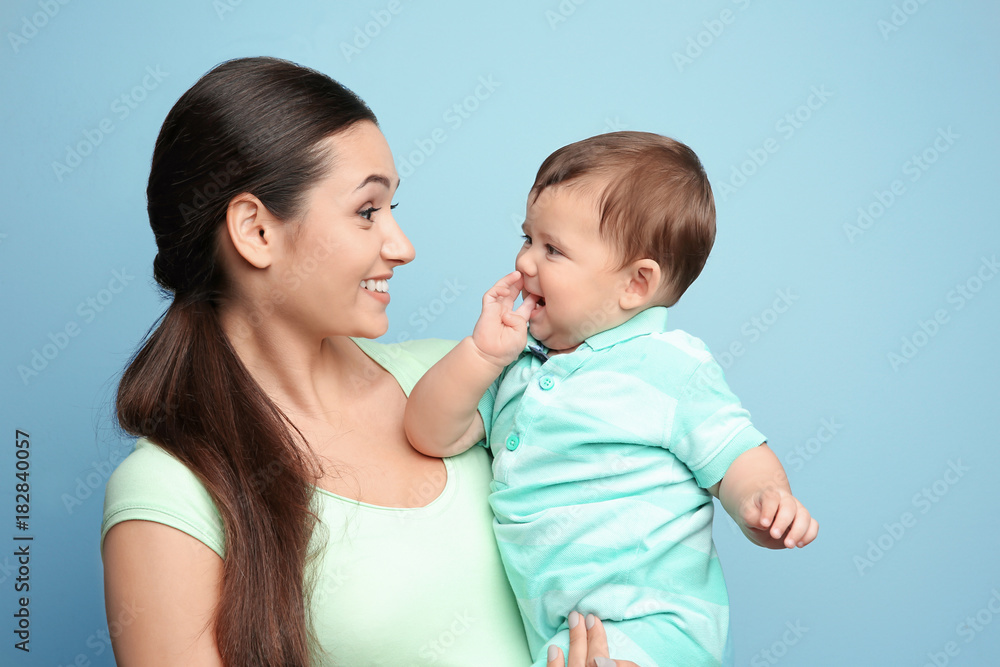 Young mother with little son on color background Young mother with little son on color background
