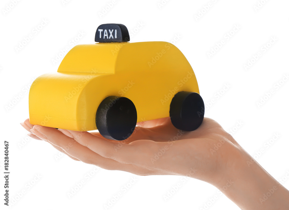 Woman holding yellow toy taxi cab on white background, closeup Woman holding yellow toy taxi cab on white background, closeup