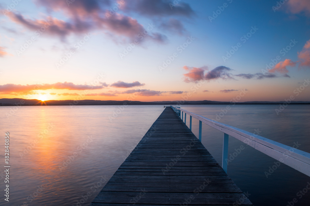 Sunset view of long jetty into the lake.