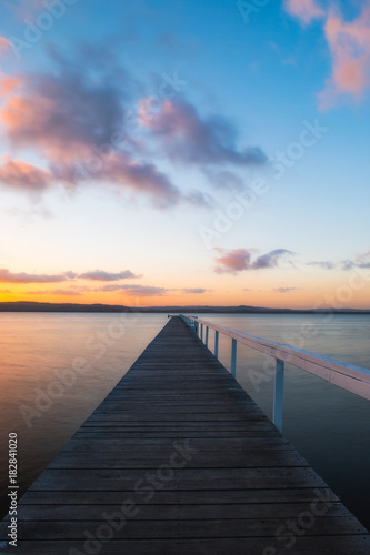 An empty view of long jetty during sunset time.