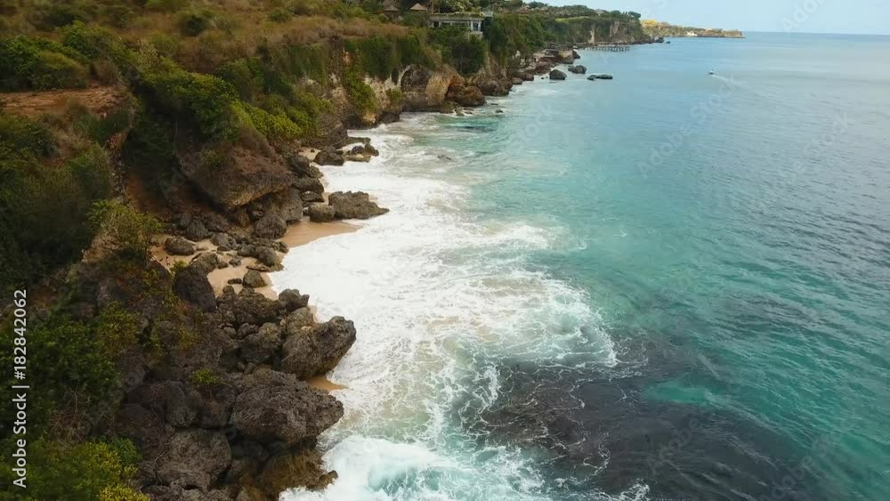 Beach with rocky mountains and clear water of Indian ocean at sunny day, Bali,Indonesia. Waves break on rocky shore. Seascape, rocks, ocean, beach.4K video. Travel concept. Aerial footage. Beach with rocky mountains and clear water of Indian ocean at sunny day, Bali,Indonesia. Waves break on rocky shore. Seascape, rocks, ocean, beach.4K video. Travel concept. Aerial footage.