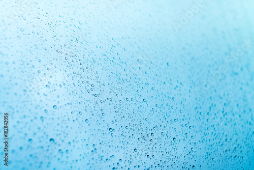 Blue background of rain drops on a window